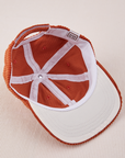 Dugout Corduroy Hat in Burnt Terracotta flipped over. White satin under-bill.