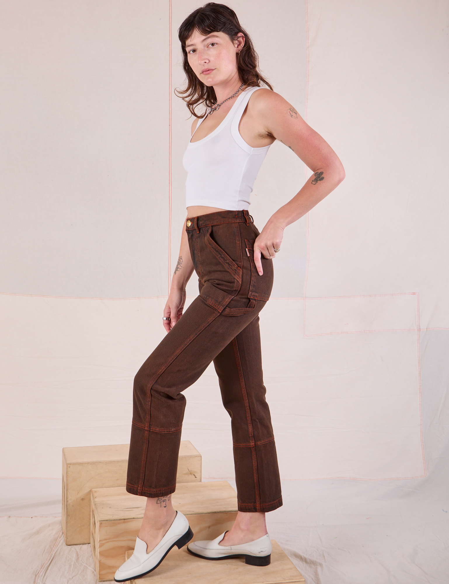 Side view of Overdyed Carpenter Jeans in Fudge and Cropped Tank in vintage tee off-white