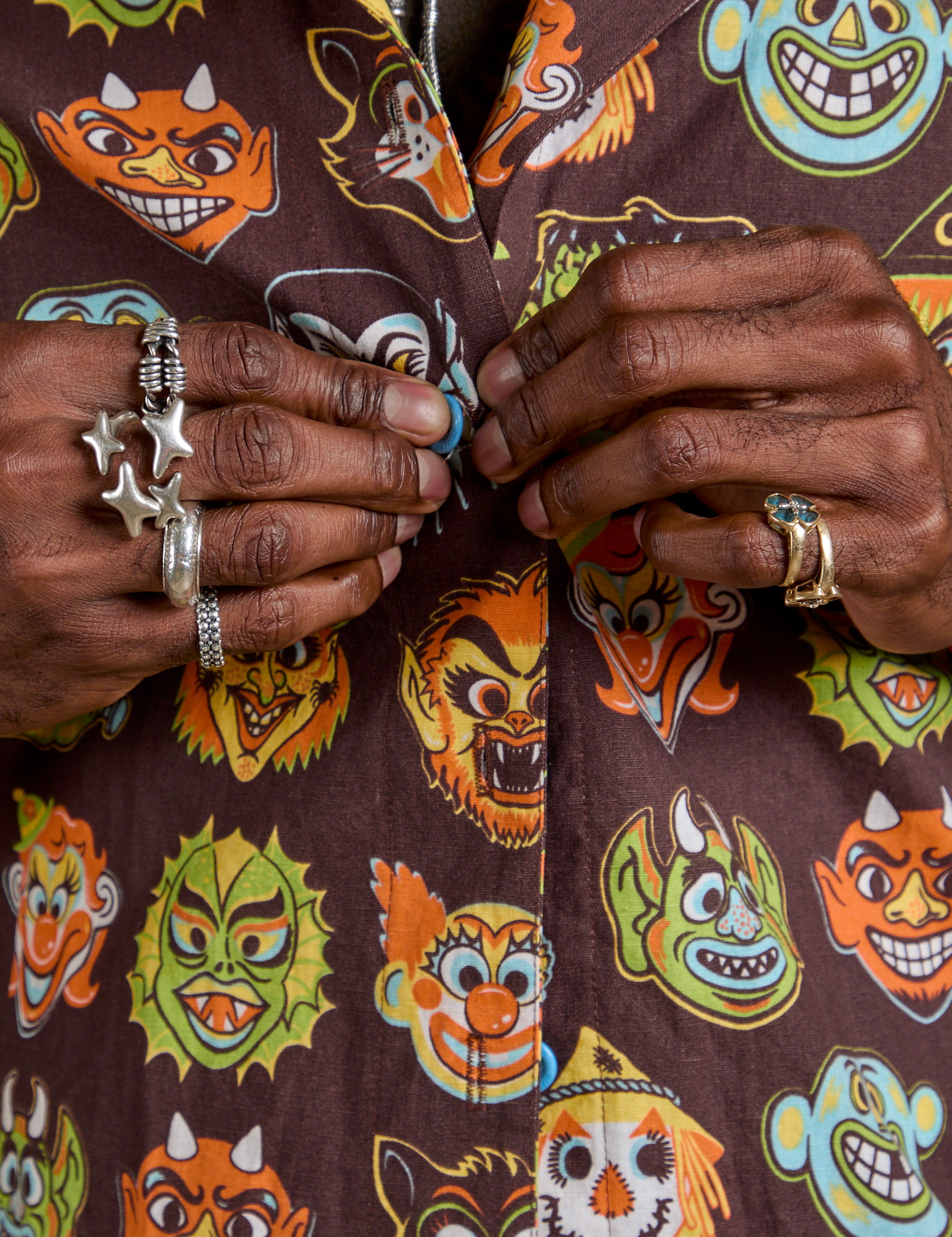 Close up of Jerrod buttoning the Halloween Masks Pantry Button-Up