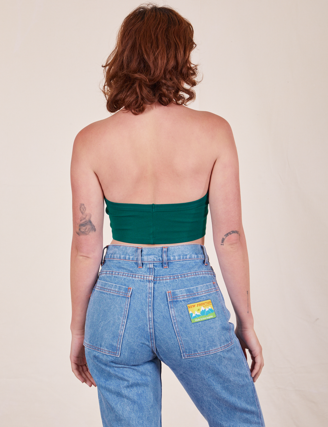 Back view of Halter Top in Hunter Green and light wash Frontier Jeans worn by Alex