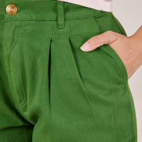 Front close up of Heavyweight Trousers in Lawn Green. Tiara has her hand in the pocket.