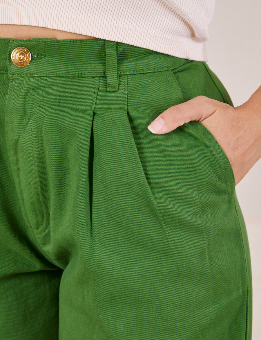 Front close up of Heavyweight Trousers in Lawn Green. Tiara has her hand in the pocket.