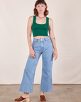Alex is wearing Cropped Tank Top in Hunter Green and light wash Sailor Jeans