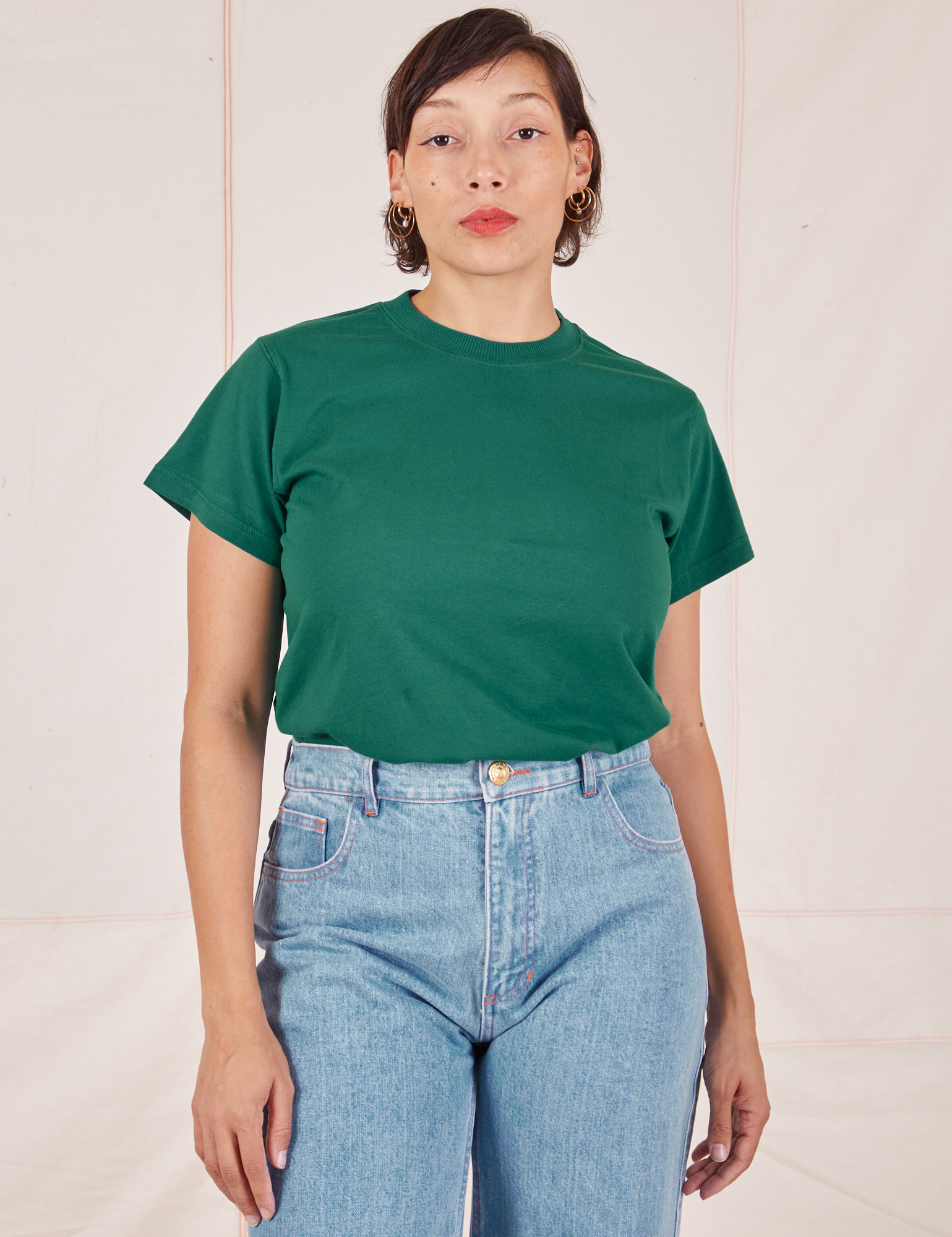 Tiara is wearing Organic Vintage Tee in Hunter Green tucked into light wash Sailor Jeans
