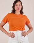 Tiara is wearing JV Tee in Construction Orange tucked into vintage tee off-white Western Pants