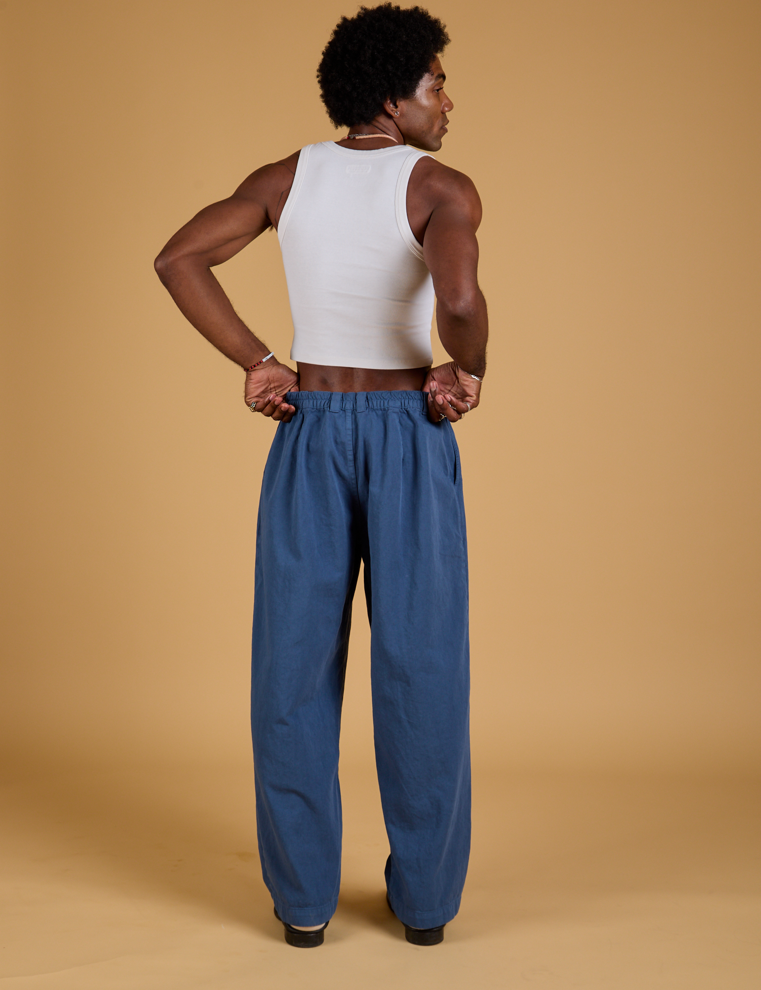 Back view of Baggy Mid-Rise Trousers in French Blue and vintage tee white Cropped Tank on Jerrod