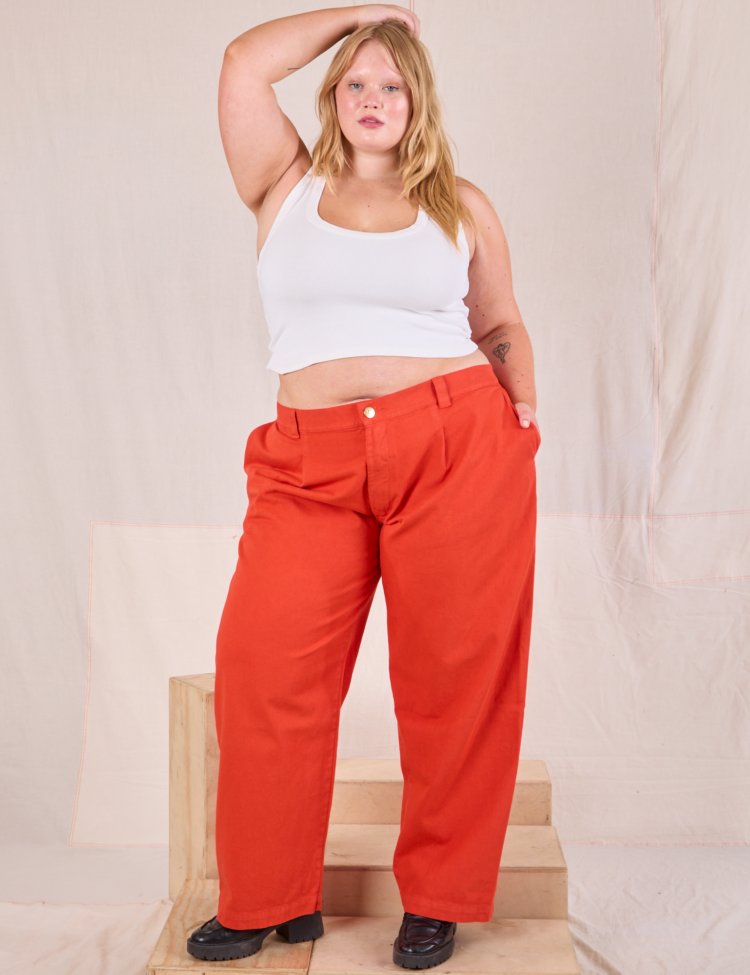 Juliet is 5&#39;7&quot; and wearing 0XL Mid-Rise Pleated Trousers in Chili Red paired with a Cropped Tank in vintage tee off-white