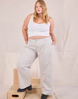 Juliet is 5'7" and wearing 0XL Mid-Rise Pleated Trousers in Stone White paired with a Cropped Tank in Vintage Tee Off-White