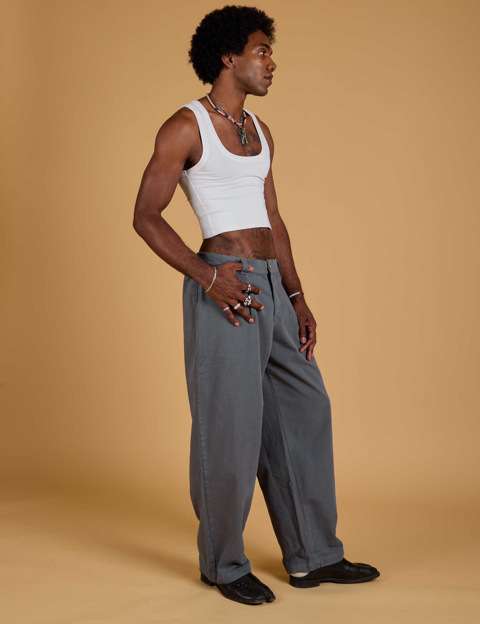 Angled front view of Baggy Mid-Rise Trousers in Slate Grey and vintage tee white on Jerrod