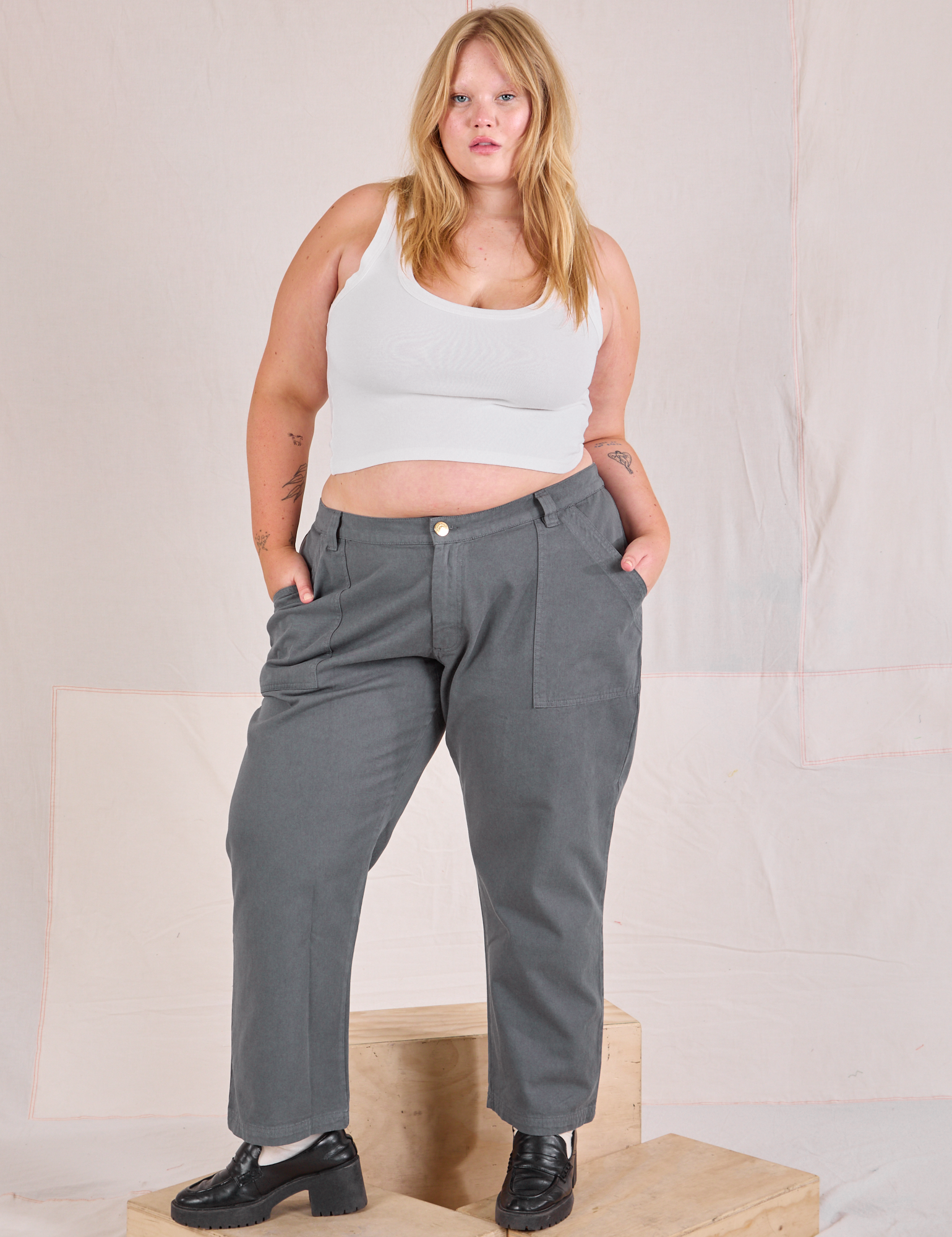 Juliet is 5&#39;7&quot; and wearing 2XL Mid-Rise Work Pants in Slate Grey paired with a Cropped Tank in vintage tee off-white