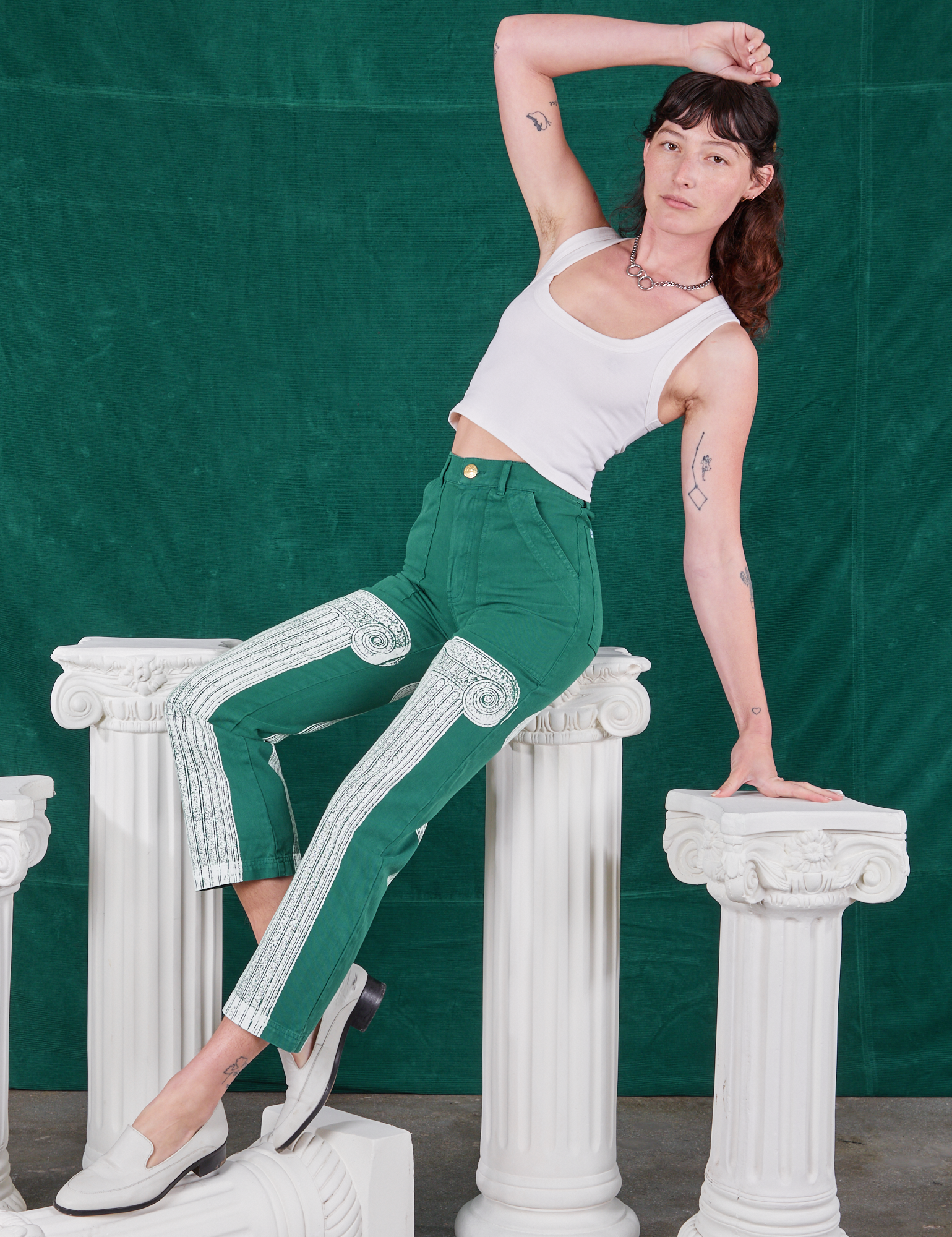 Alex is wearing Column Work Pants in Hunter Green and vintage off-white Cropped Tank Top