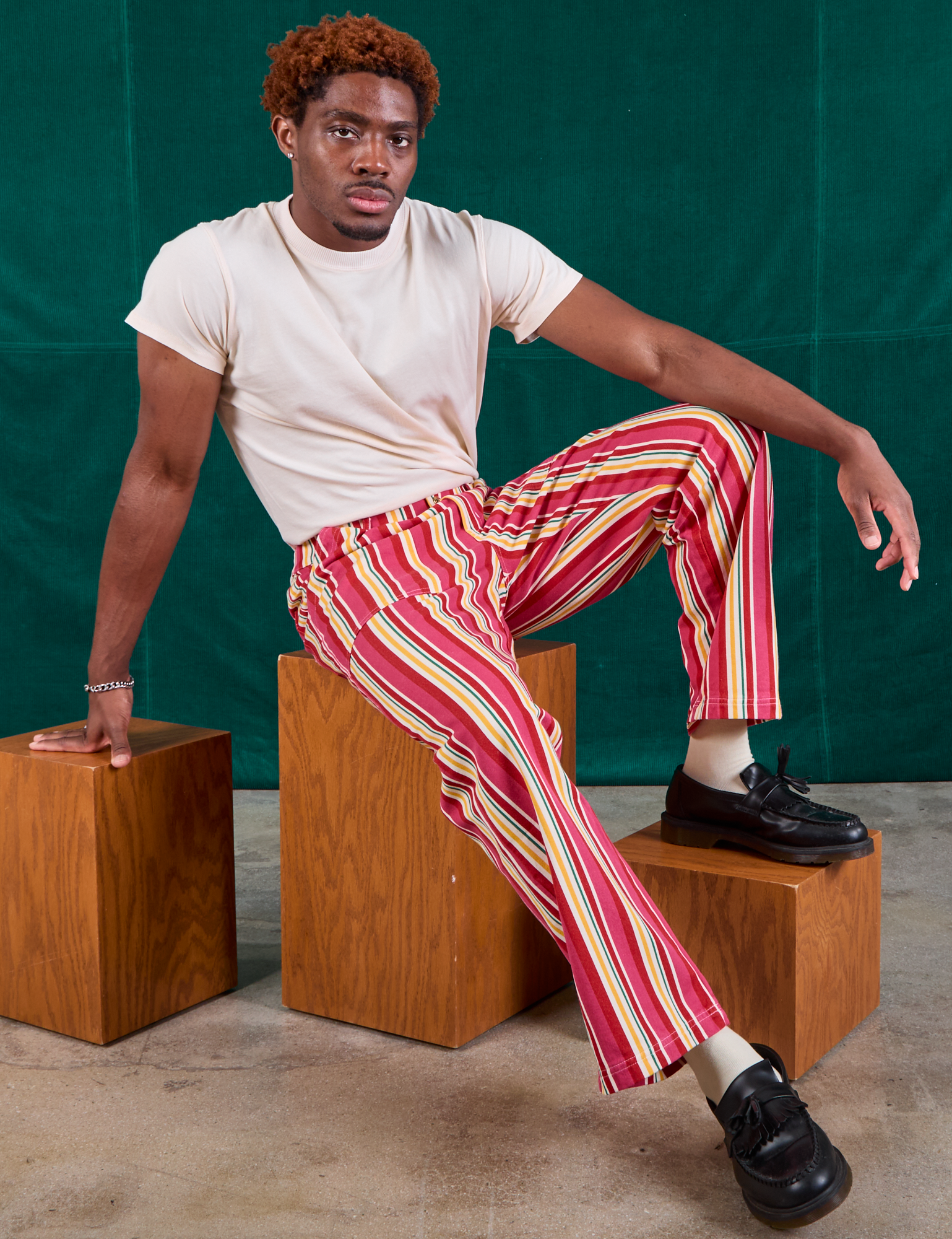 Issac is wearing Stripe Work Pants in Cherry Candy and Organic Vintage Tee in vintage tee off-white