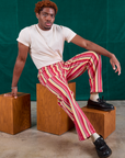 Issac is wearing Stripe Work Pants in Cherry Candy and Organic Vintage Tee in vintage tee off-white