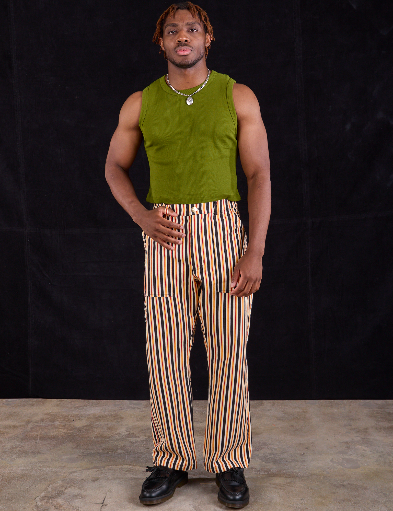 Issac is wearing Work Pants in Autumn Stripe and summer olive Muscle Tee