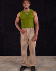 Issac is wearing Work Pants in Autumn Stripe and summer olive Muscle Tee