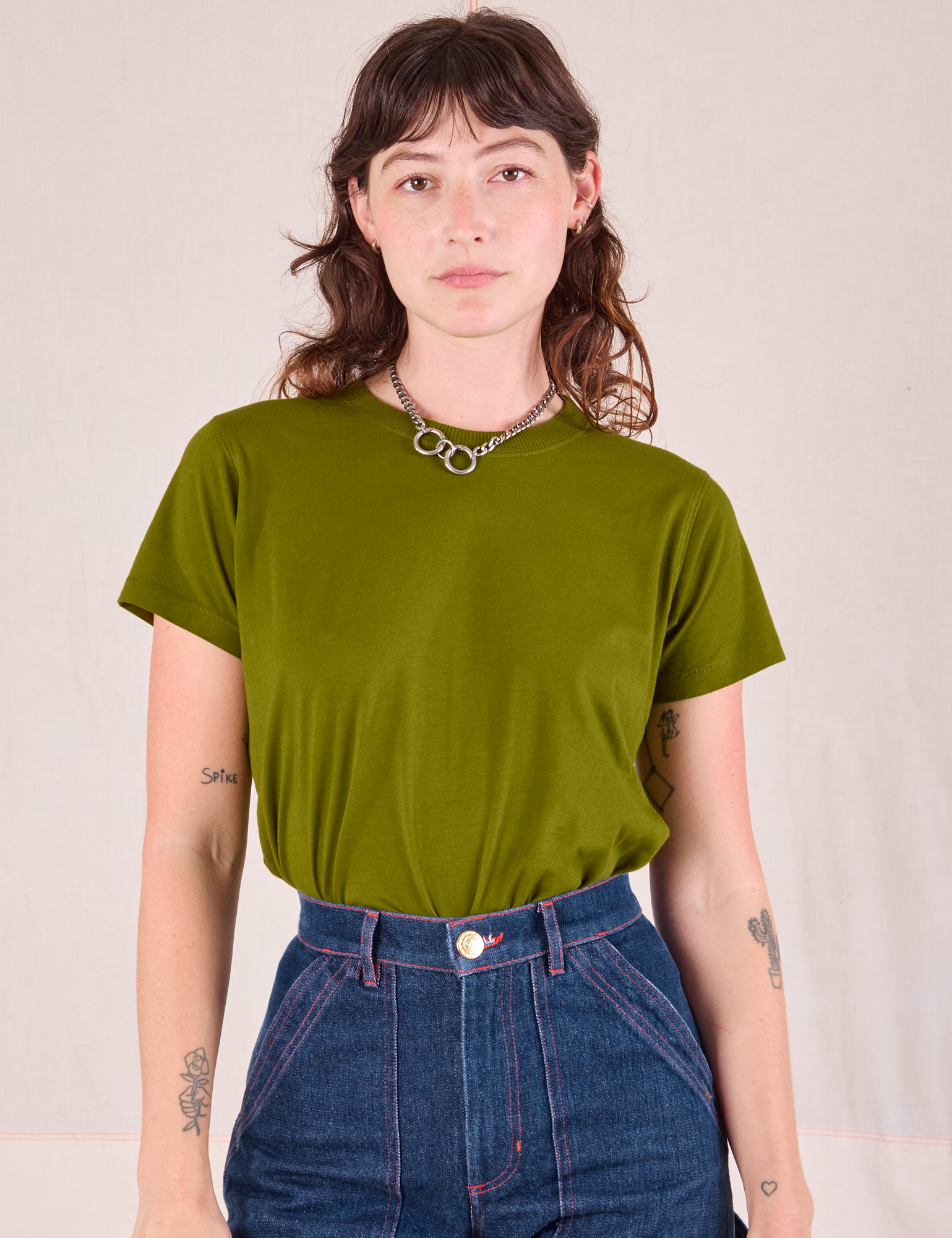 Alex is wearing Organic Vintage Tee in Summer Olive tucked into dark wash Carpenter Jeans