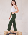 Side view of Organic Work Pants in Swamp Green and Racerback Tank in vintage tee off-white on Alex