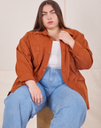 Marielena is wearing Oversize Overshirt in Burnt Terracotta with vintage off-white Cropped Tank Top and light wash Sailor Jeans