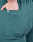 Back pocket close up of Petite Short Sleeve Jumpsuit in Marine Blue. Ashley has her hand in the pocket.