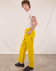 Side view of Work Pants in Golden Yellow and Burly Tee in Vintage Tee Off-White on Quinn