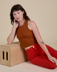 Alex is wearing Racerback Tank in Burnt Terracotta and mustang red Work Pants