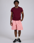 Isaac is 5’10” and wearing M Longline Work Shorts in Baby Pink paired with red with Organic Vintage Tee