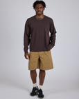 Isaac is 5’10” and wearing M Longline Work Shorts in Desert Brown paired with espresso brown Long Sleeve Burly Tee