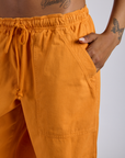 Close up of Kira's hand in the front pocket of Drop Pocket Cargo Pants in Creamsicle Orange