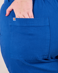 Short Sleeve Jumpsuit in Royal Blue back pocket close up with Juliet's hand in pocket.