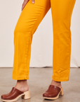 Side view pant leg close up of Short Sleeve Jumpsuit in Mustard Yellow worn by Gabi