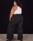 Angled back view of Star Bell Bottoms in Black and Cropped Tank in vintage tee off-white