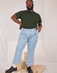 Elijah is wearing Organic Vintage Tee in Swamp Green tucked into light wash Carpenter Jeans