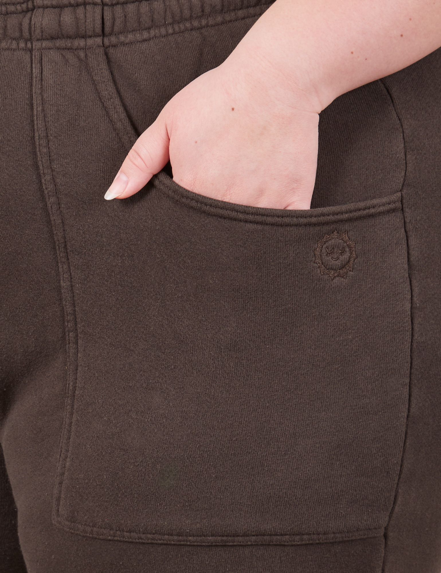 Cropped Rolled Cuff Sweatpants in Espresso Brown front pocket close up. Ashley has her hand in the pocket.