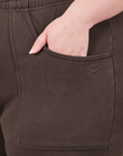 Cropped Rolled Cuff Sweatpants in Espresso Brown front pocket close up. Ashley has her hand in the pocket.