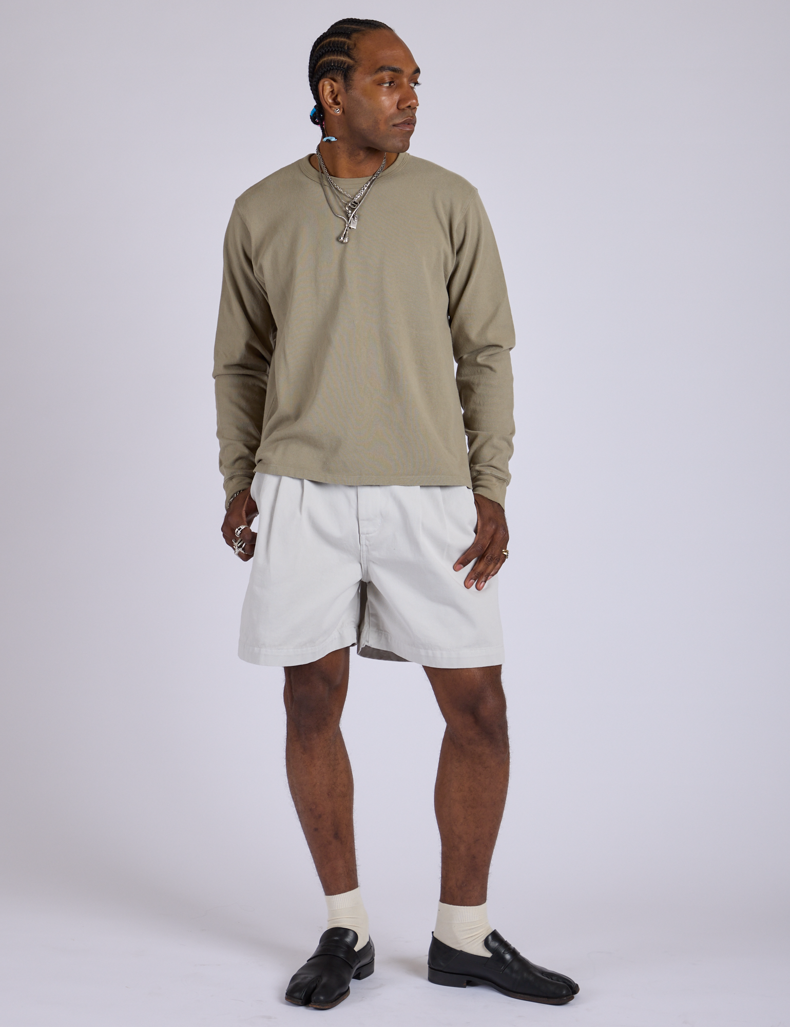 Jerrod is wearing Pleated Trouser Shorts in Dishwater White and Long Sleeve Burly Tee in Khaki Grey