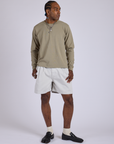 Jerrod is wearing Pleated Trouser Shorts in Dishwater White and Long Sleeve Burly Tee in Khaki Grey