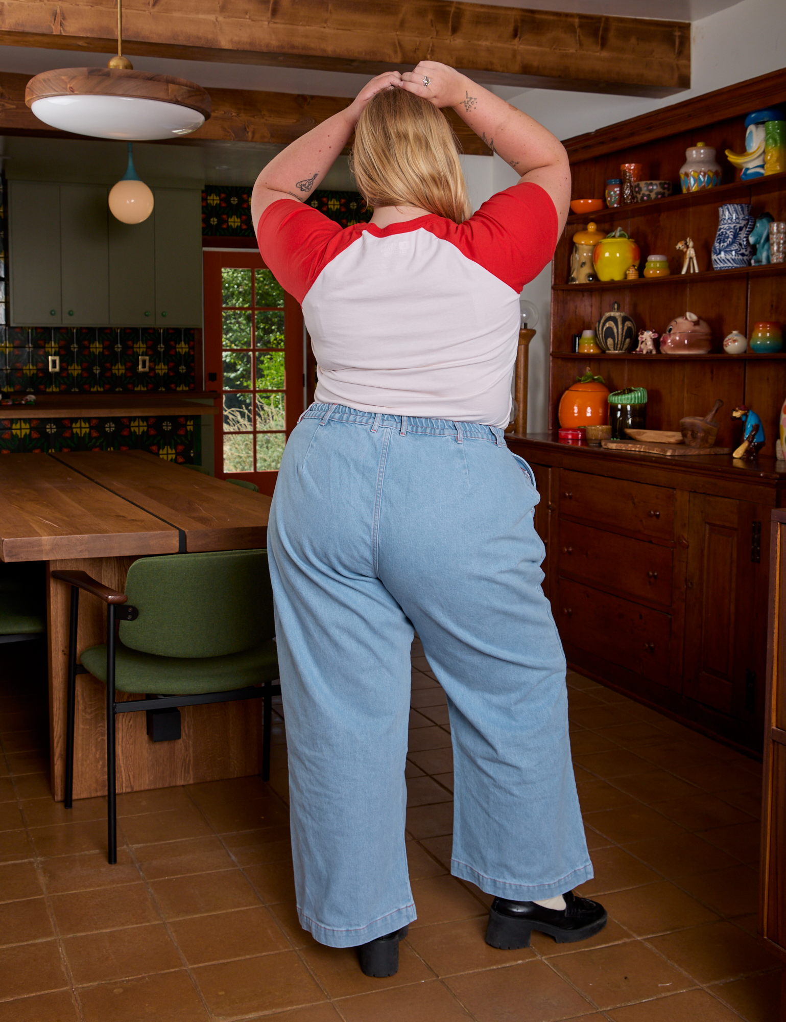 Back view of Short Sleeve Raglan Tee in Tomatoes and light wash Indigo Wide Leg Trousers on Juliet