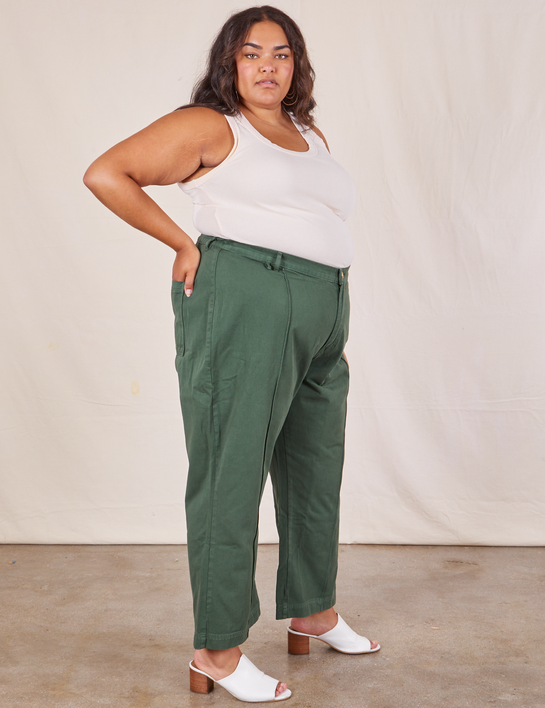 Side view of Western Pants in Dark Green Emerald and vintage off-white Tank Top worn by Alicia