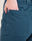 Western Shorts in Lagoon back pocket close up. Margaret has their hands in the pocket.
