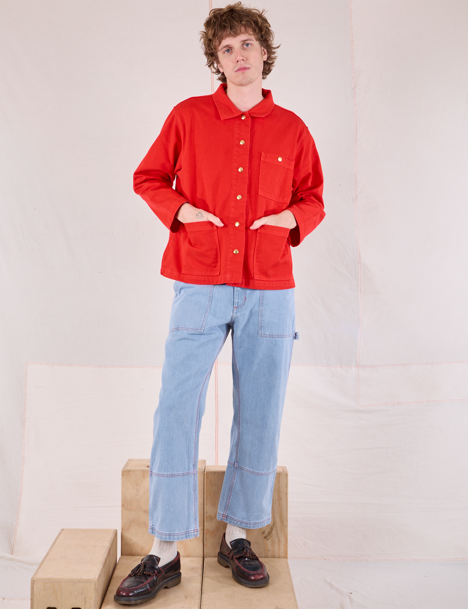 Quinn is wearing Denim Work Jacket in Mustang Red and light wash Carpenter Jeans