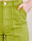 Work Pants in Gross Green front close up. Margaret has her hand in the pocket.