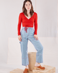 Hana is wearing Wrap Top in Mustang Red and light wash Carpenter Jeans