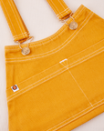 Overall Handbag in Mustard Yellow. Contrast white stitching. Brass sun baby buttons and hardware.