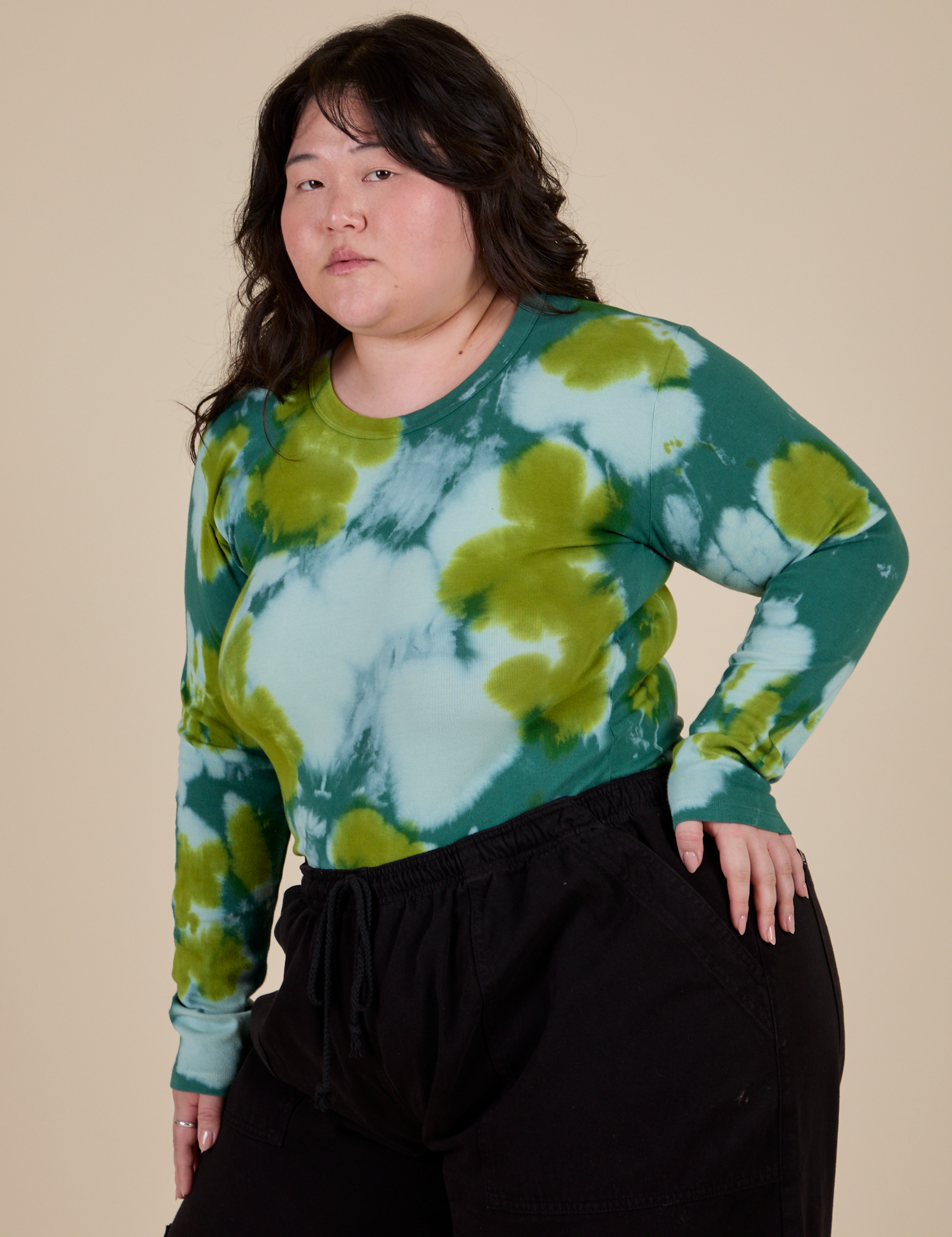 Angled front view of Long Sleeve Baby Tee in Green Magic Waters on Ashley