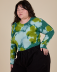 Angled front view of Long Sleeve Baby Tee in Green Magic Waters on Ashley