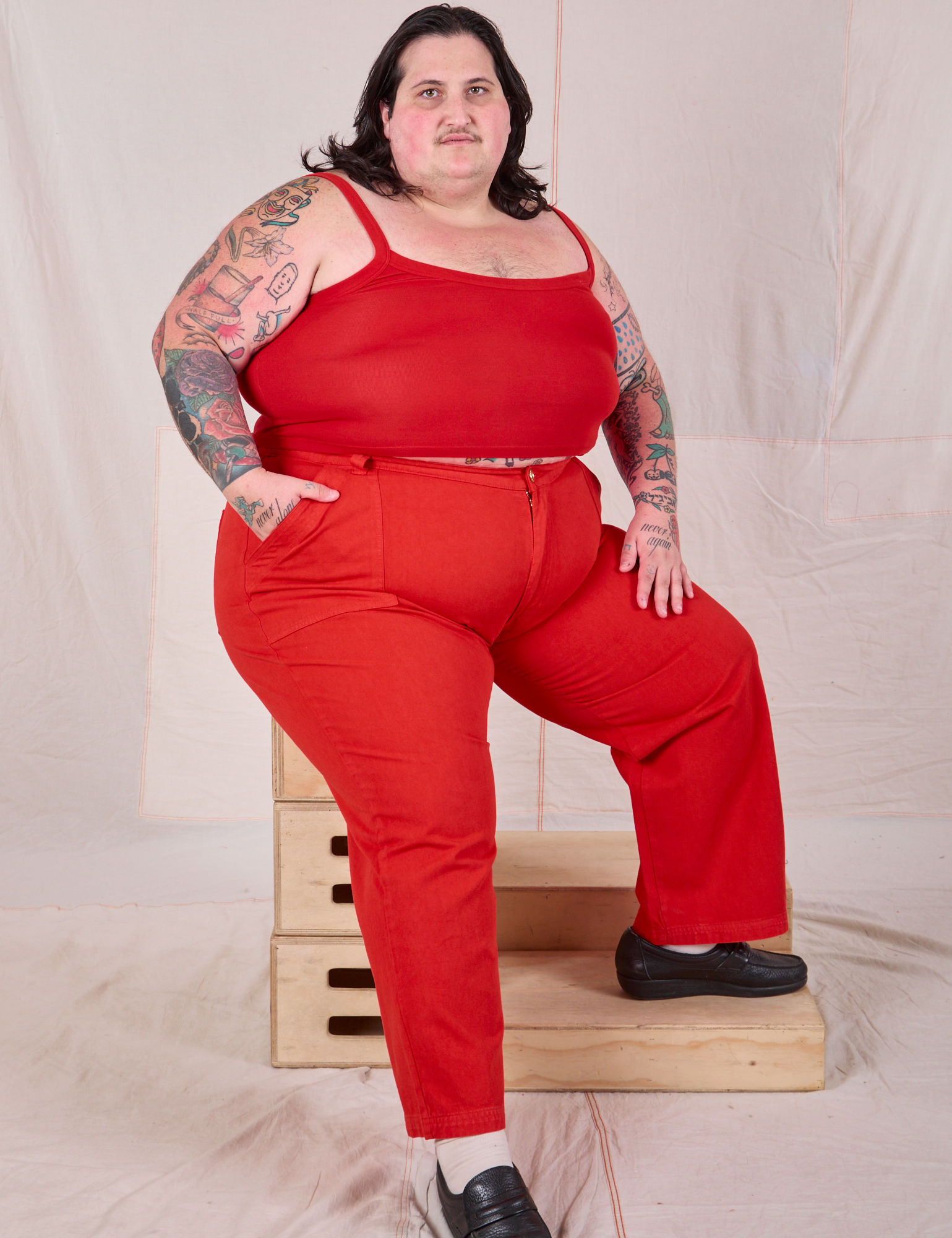 Sam is wearing Mid-Rise Work Pants in Mustang Red and matching Cropped Cami