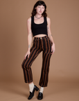 Alex is wearing Black Stripe Work Pants in Fudgesicle Brown and black Cropped Tank