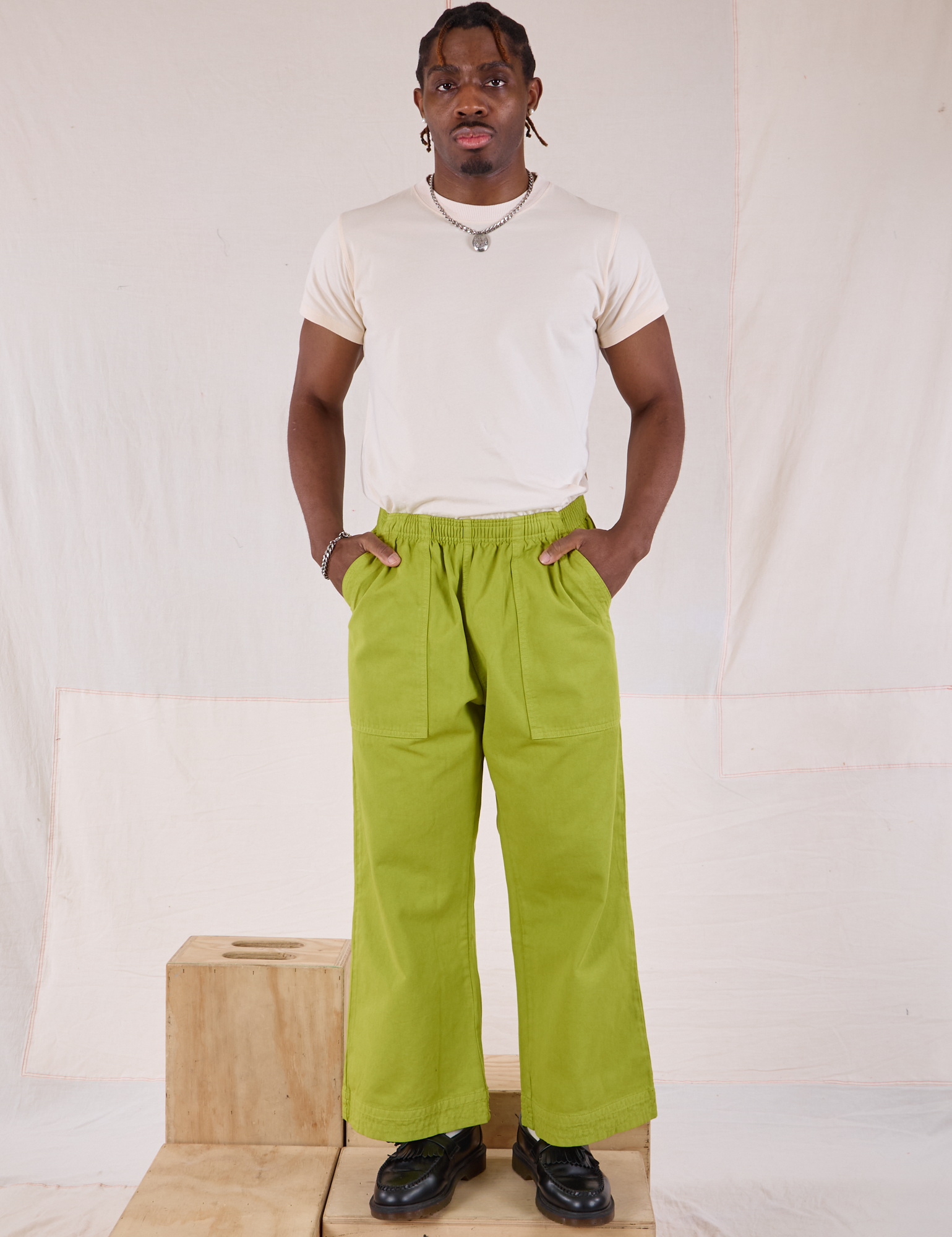 Isaac is 5&#39;10&quot; and wearing M Action Pants in Gross Green paired with Organic Vintage Tee in Vintage Tee Off-White