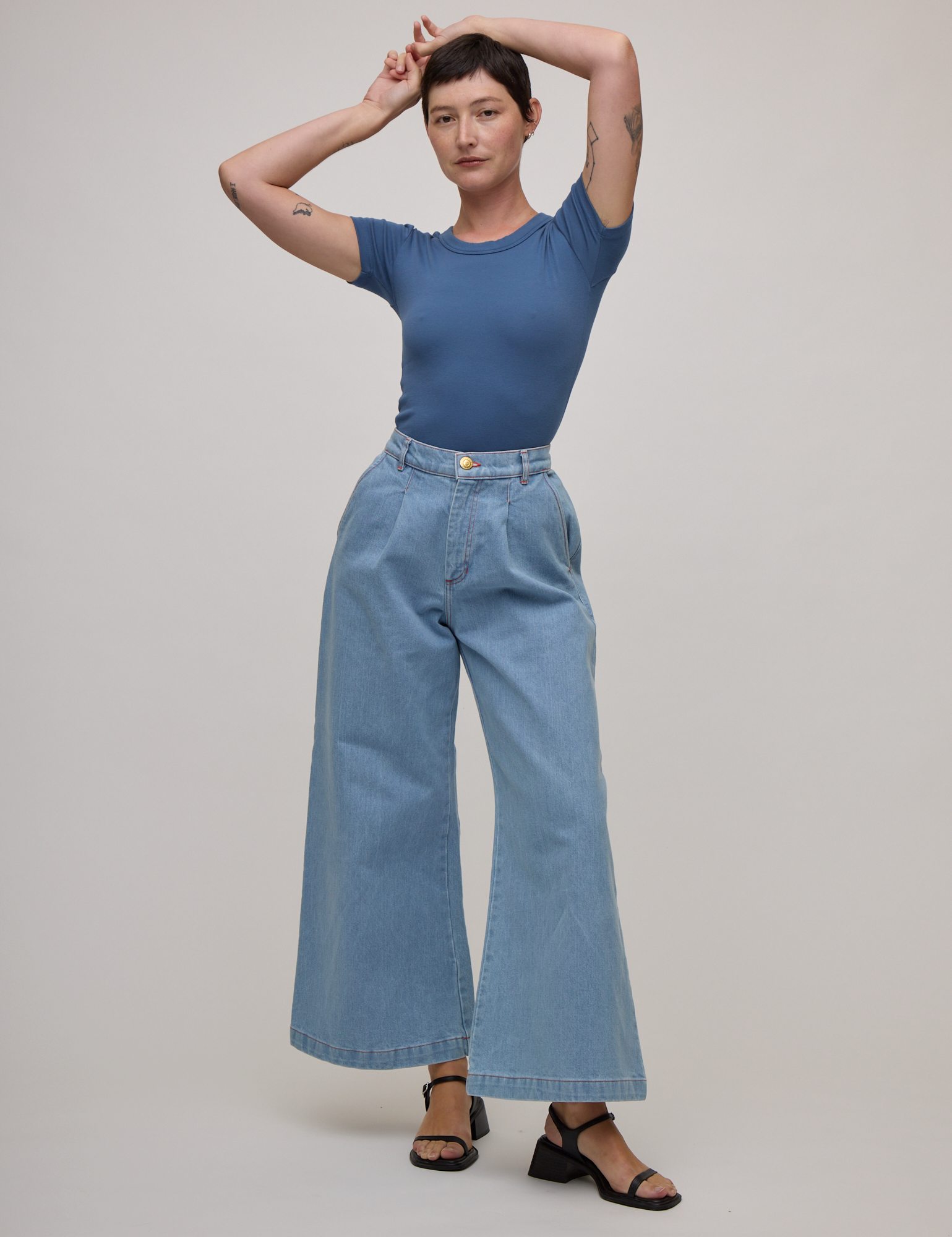 Alex is wearing Baby Tee in French Blue and light wash denim wide leg trousers