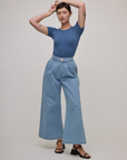 Alex is wearing Baby Tee in French Blue and light wash denim wide leg trousers
